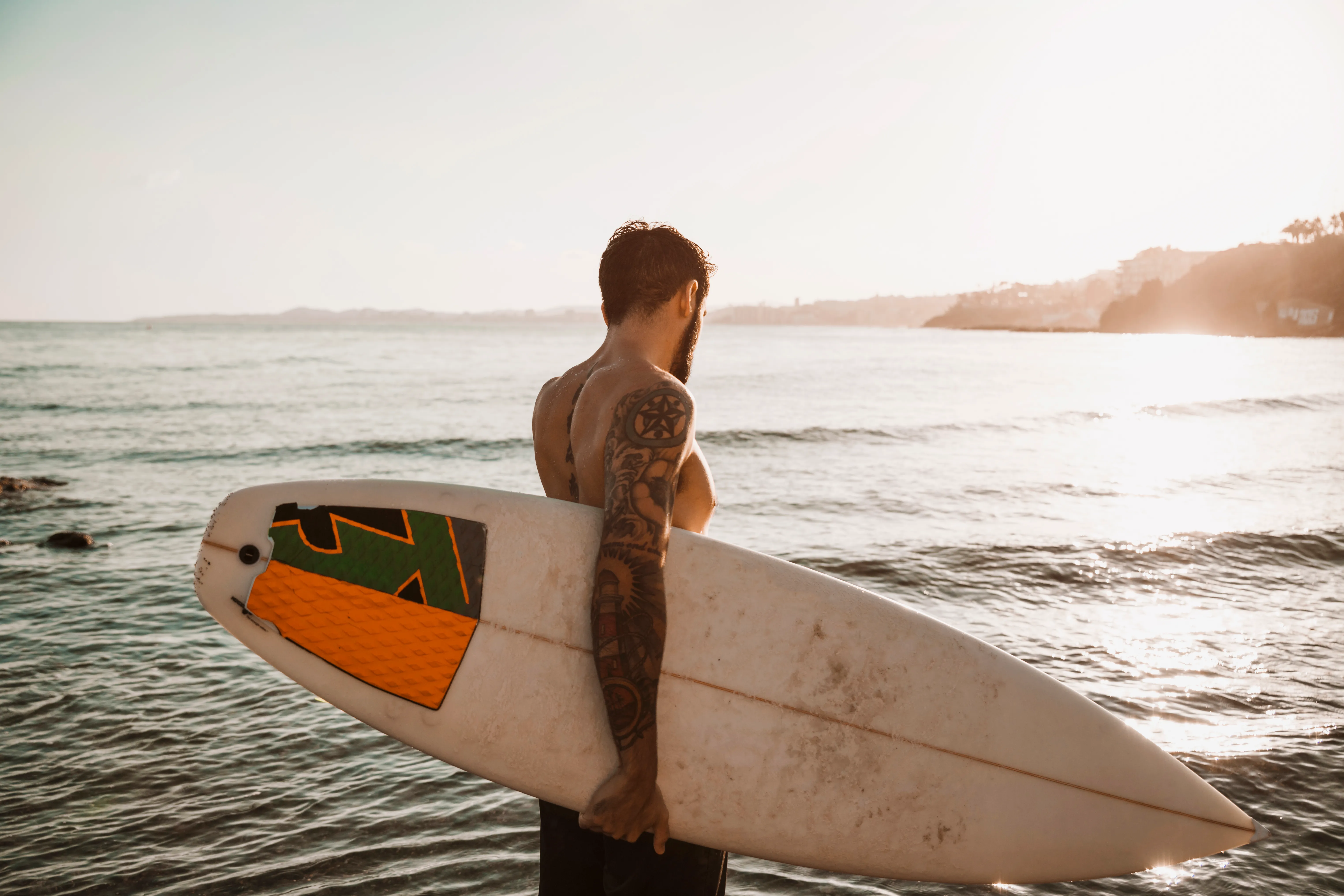 Homem com prancha na praia